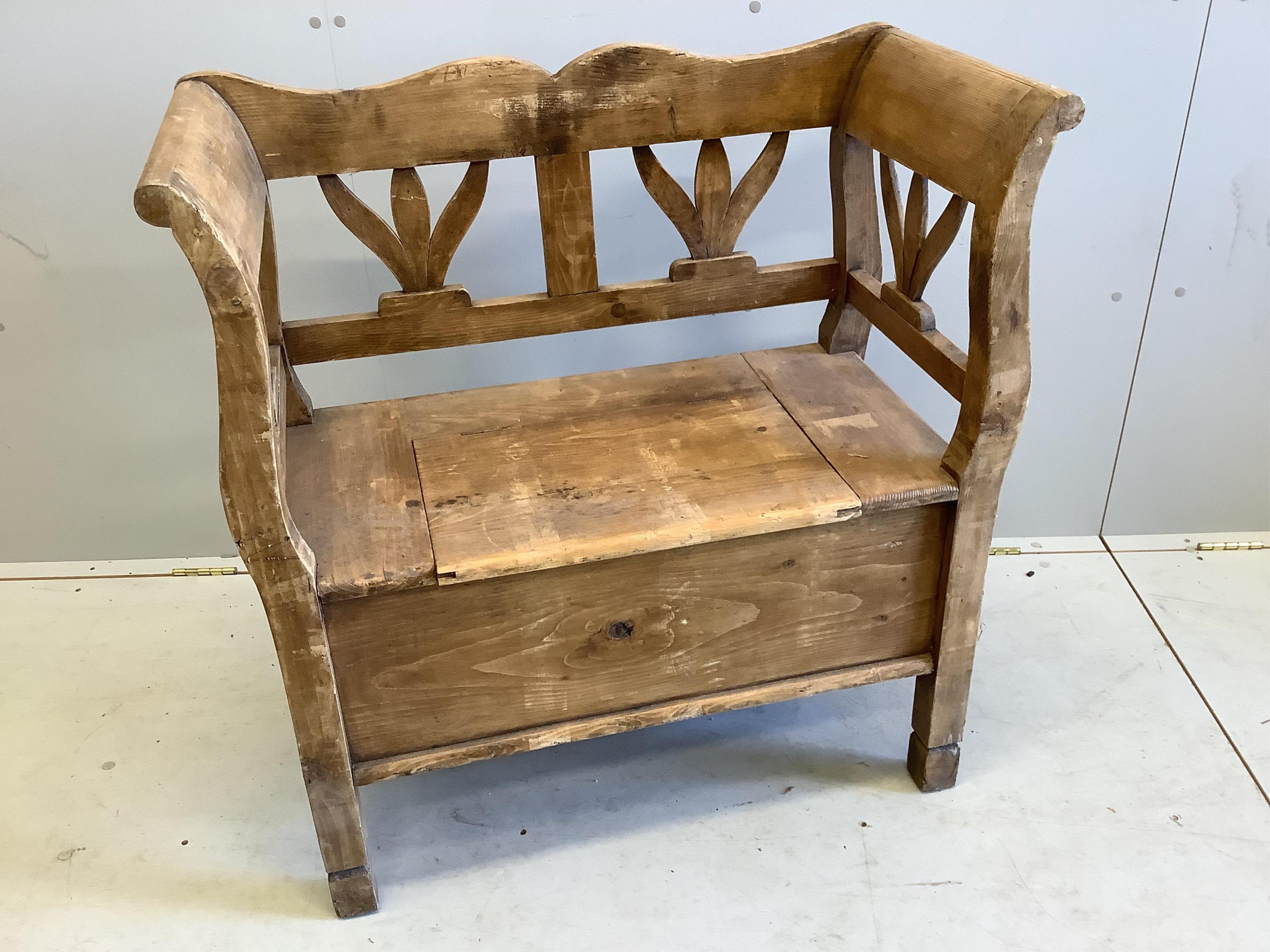 A 19th century Continental pine settle with hinged box seat, width 86cm, depth 41cm, height 89cm